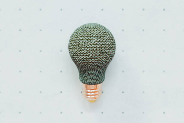 Knitted light bulb against turquoise backdrop with polka dots conceptual 3D illustration