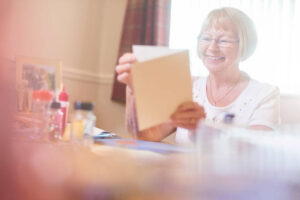 lady smiling while holding and looking at hand made card