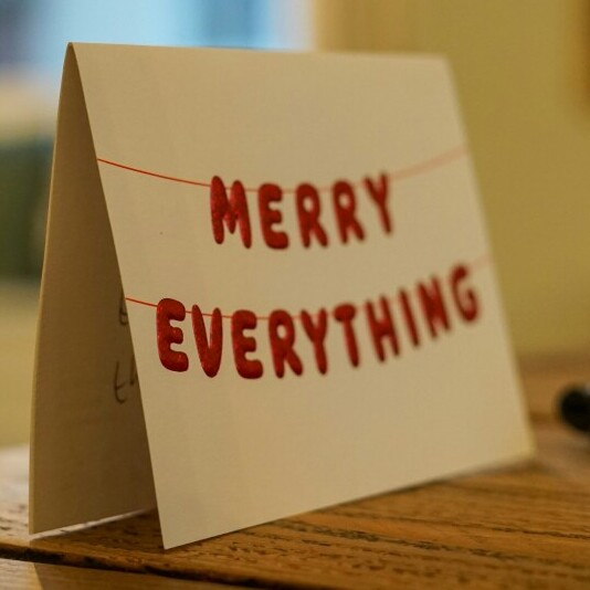 face of a handmade eco-friendly Christmas card with the words Merry everything in red