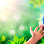 Childs hand touching an Adults Hand that is an earth globe